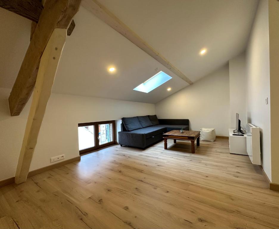 sala de estar con sofá y mesa en T4 Cosy dans ferme rénovée à 2 minutes de Genève en Collonges-sous-Salève