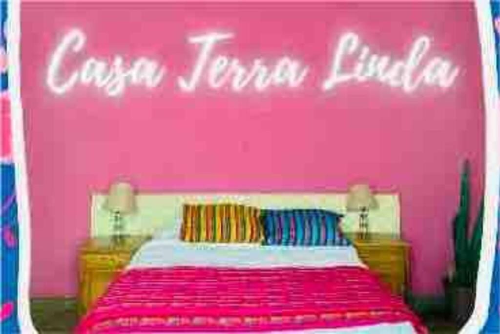une chambre rose avec un lit aux murs roses dans l'établissement CASA TERRA LINDA, à San Luis Potosí