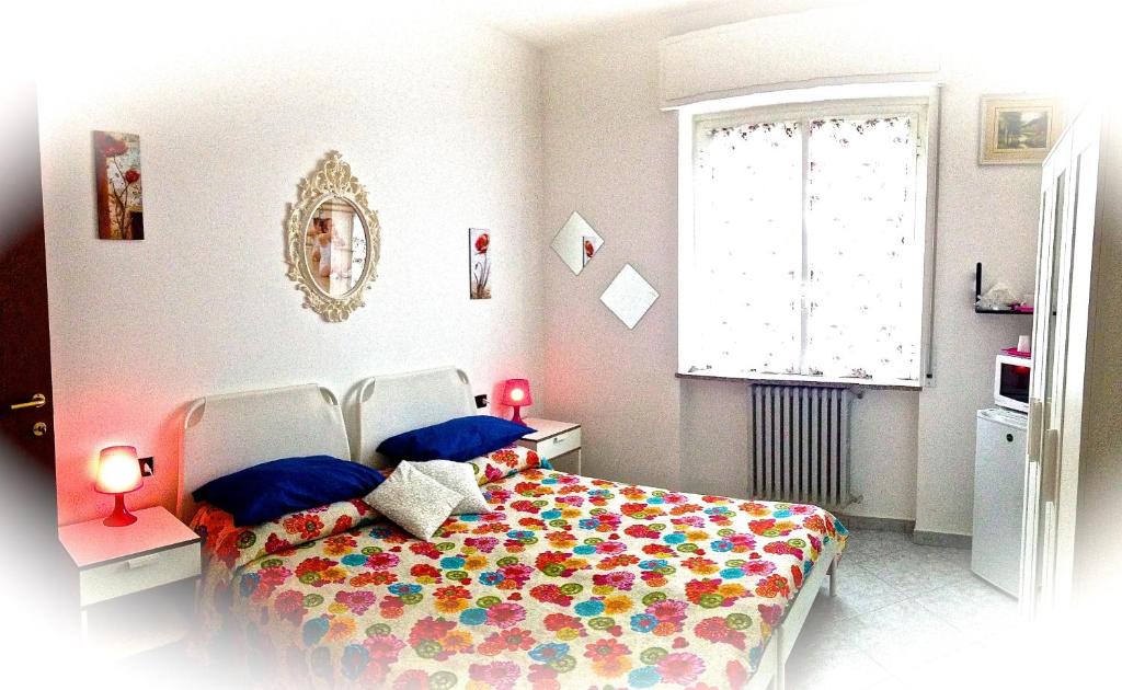 een slaapkamer met een bed met een kleurrijk dekbed bij Top Suit Uno - Guest house in Brugherio