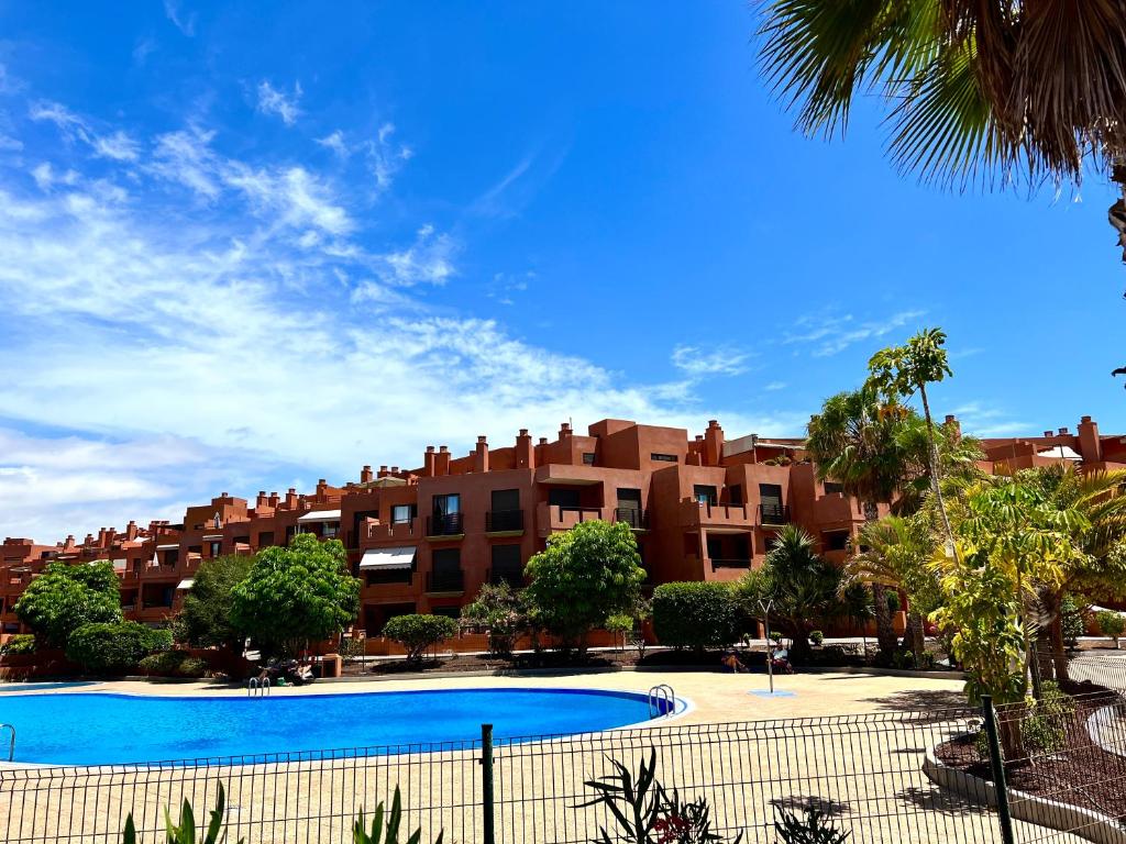 a large apartment building with a large swimming pool at Apartament with Garden in La Tejita