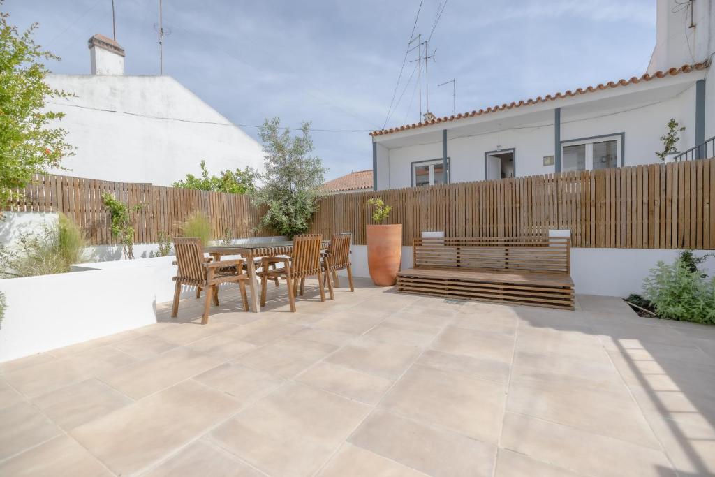 Un patio con mesa y sillas y una valla. en Bento Caraça Terrace, en Alcácer do Sal