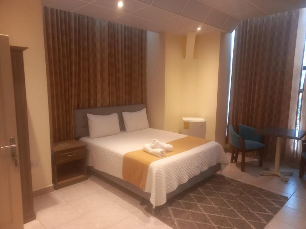 Hotel Las Peñas في غواياكيل: غرفة نوم عليها سرير وفوط