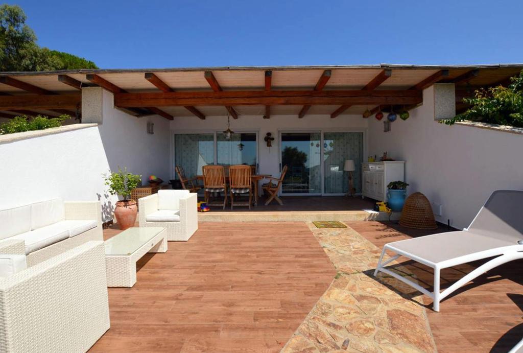 patio con muebles blancos y pérgola de madera en Villa Erica a Valle Dell Erica, en Valle Dell’Erica