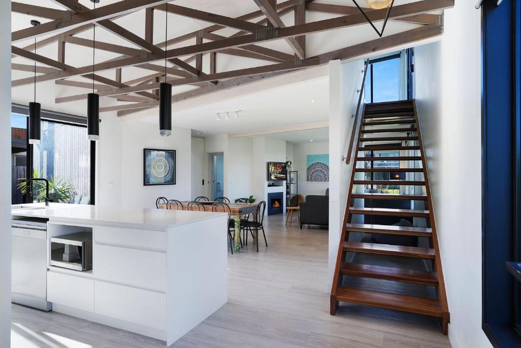 a kitchen and living room with a spiral staircase at Bliss at South Beach in Port Fairy