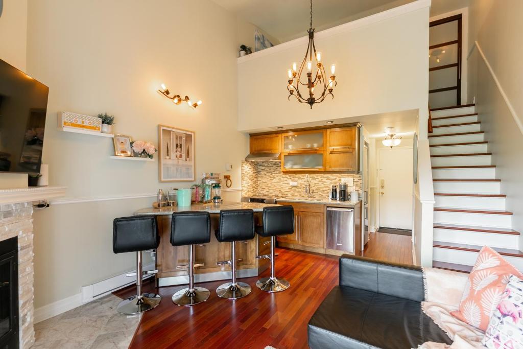 a kitchen with a bar and a living room at Le Beachside by Gestion ELITE in Mont-Tremblant