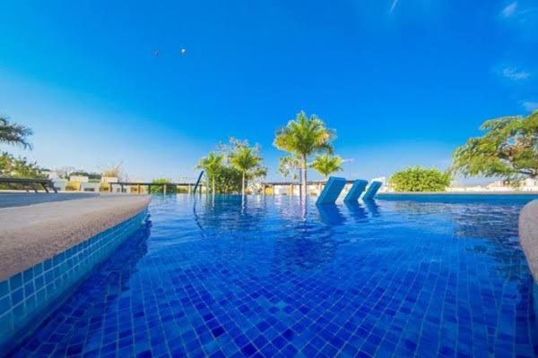 a swimming pool with blue water and palm trees at Casa Los Amores in Bucerías