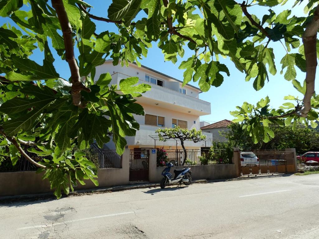 una moto parcheggiata di fronte a un edificio di Apartments with a parking space Vinisce, Trogir - 11075 a Vinišće