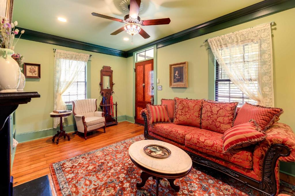 a living room with a red couch and a table at Victorian Vacation Rental Apt in Downtown New Bern in New Bern