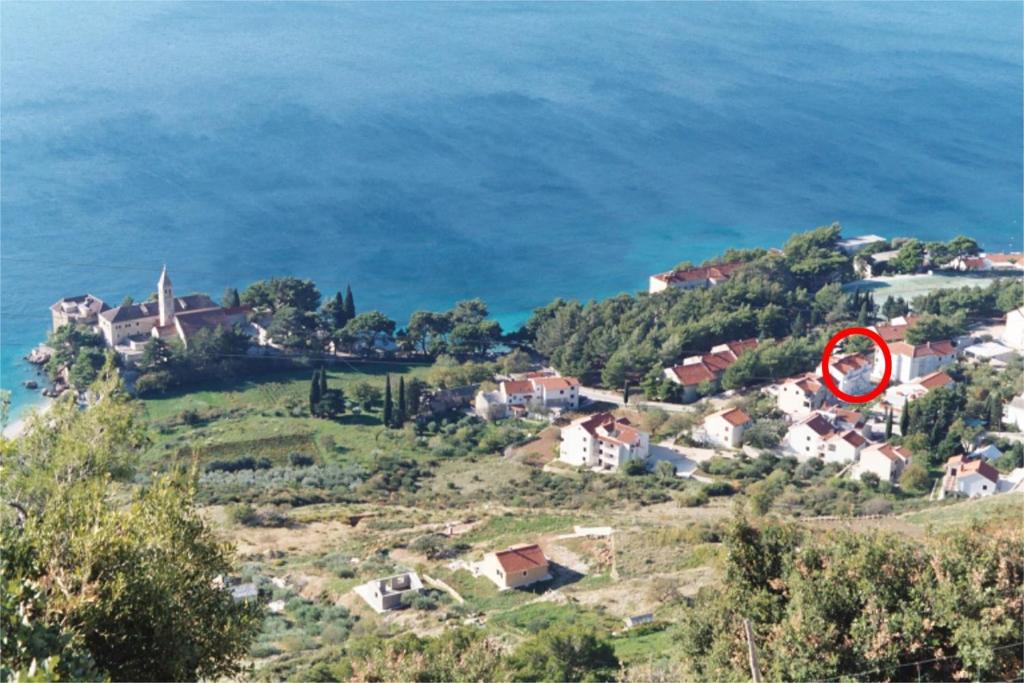 a house on a hill next to the ocean at Apartments by the sea Bol, Brac - 2904 in Bol
