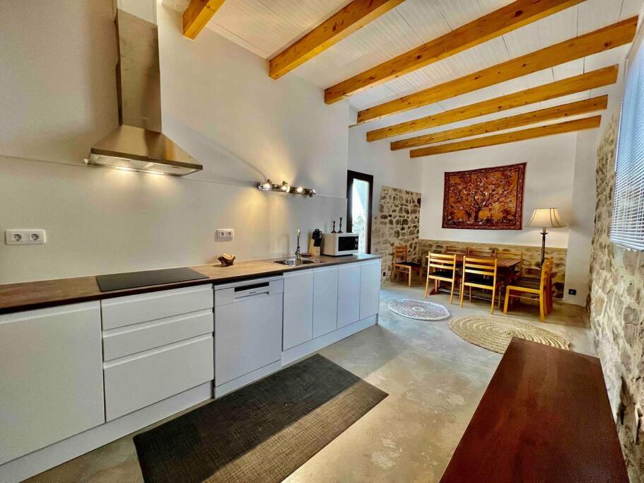 uma cozinha com armários brancos e uma sala de jantar em La Casa de Ubeda em Úbeda