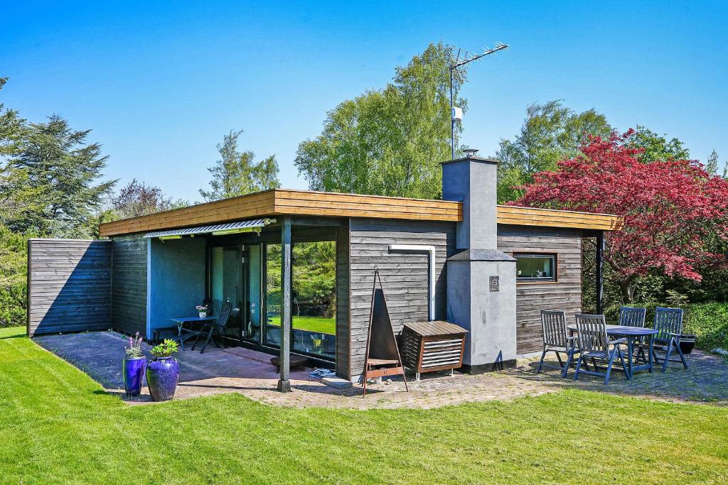 une petite maison avec une cheminée dans une cour dans l'établissement Lovely Holiday Home Close To Town And Beach, à Græsted