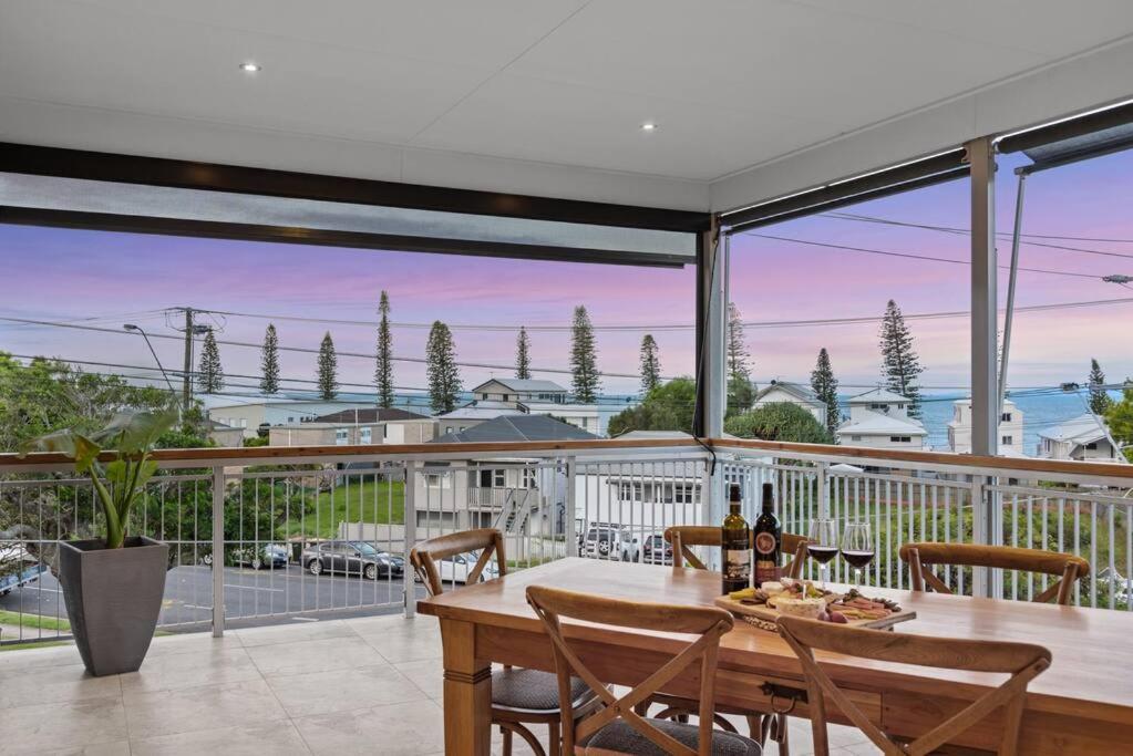 スカボローにあるPenthouse - Scarborough beach break holidaysのバルコニーにテーブルと椅子が置かれたダイニングルーム