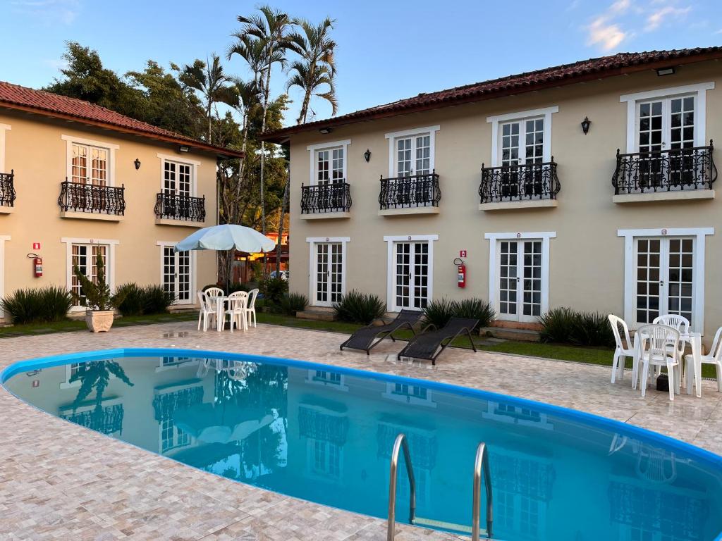 Villa con piscina frente a una casa en Pousada Portal de Paraty, en Paraty