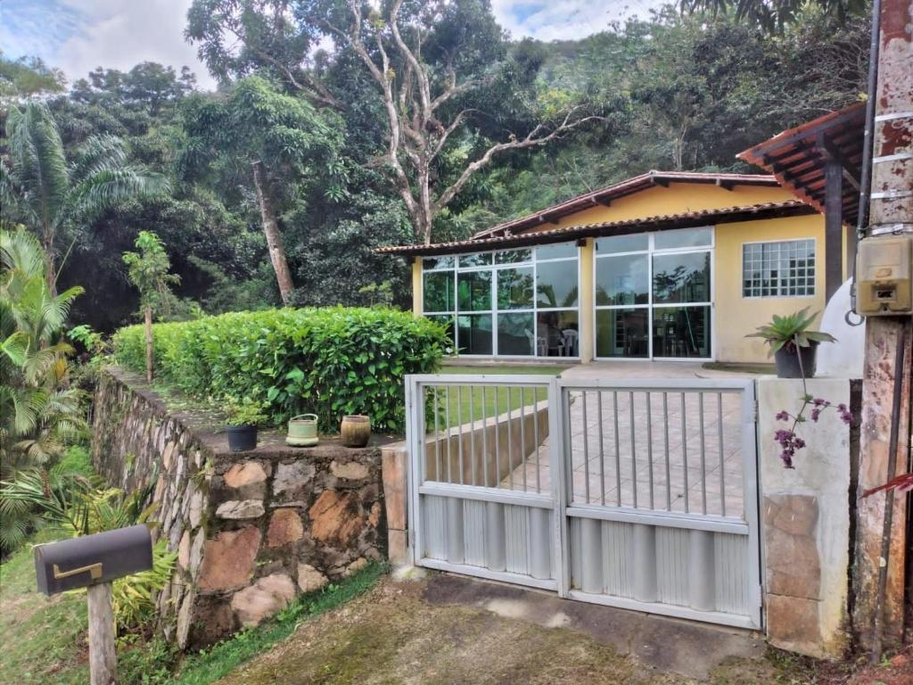 ein Haus mit einem weißen Tor und einem Zaun in der Unterkunft Linda casa em Guaramiranga in Guaramiranga