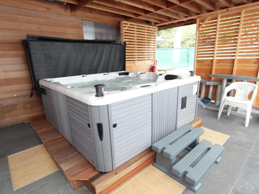 a hot tub sitting in the middle of a patio at Modern Holiday Home in Flemish Ardennes with Bubble Bath in Zottegem