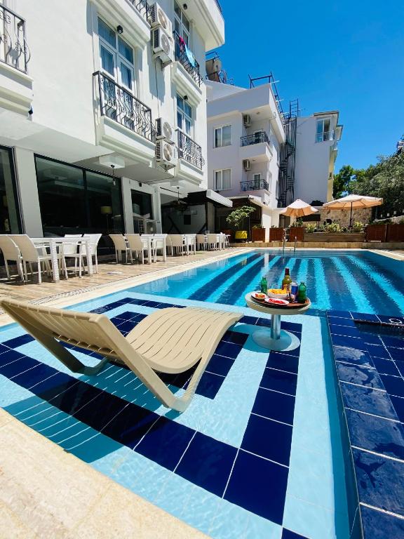 a swimming pool with a chair and a table next to a building at NFK The House Hotel in Antalya