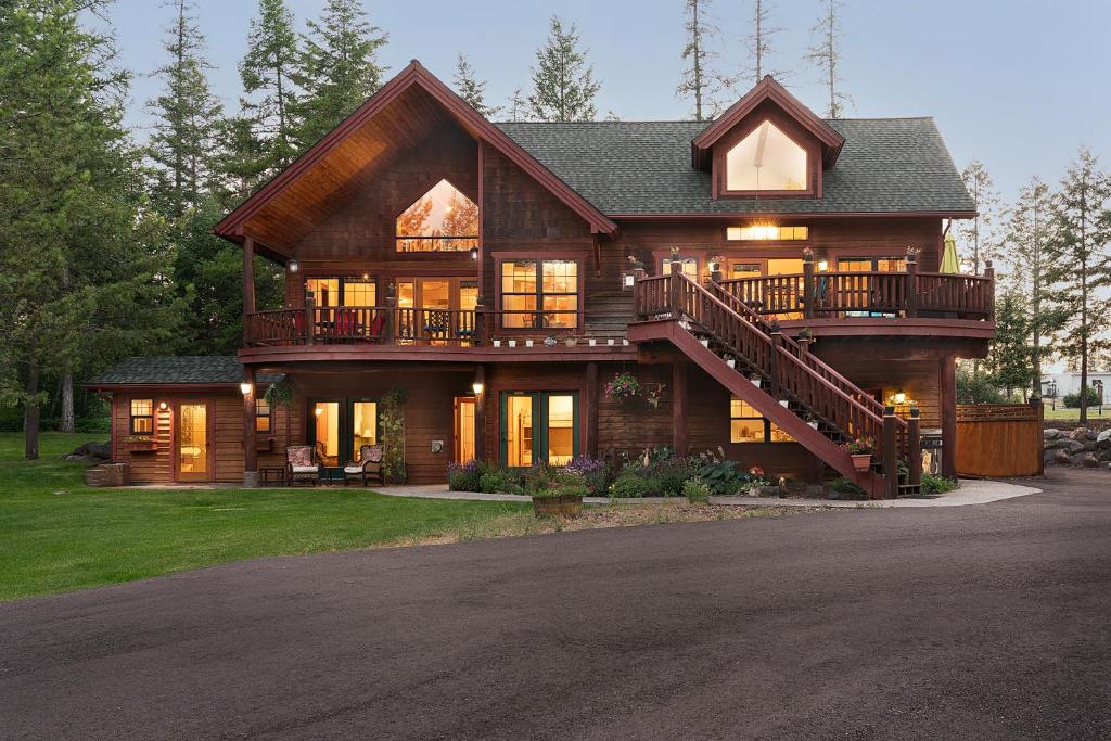 a large wooden house with a porch and a balcony at Wood's Lodge in Whitefish