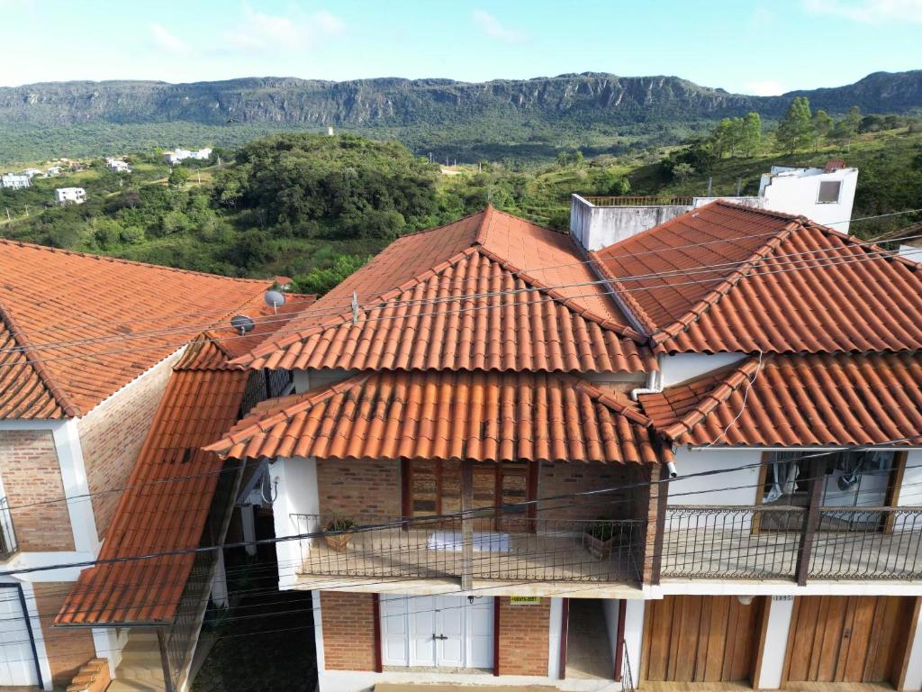 un edificio con techos de tejas naranjas y montañas de fondo en Casa Nascimento Vista Panorâmica Serra São José en Tiradentes