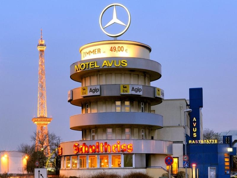 un edificio redondo con un cartel de Mercedes encima en Hotel und Rasthof AVUS, en Berlín