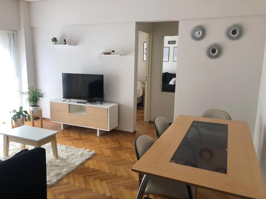 sala de estar con mesa y TV en Apartamento amoblado de 2 ambientes completo en Buenos Aires