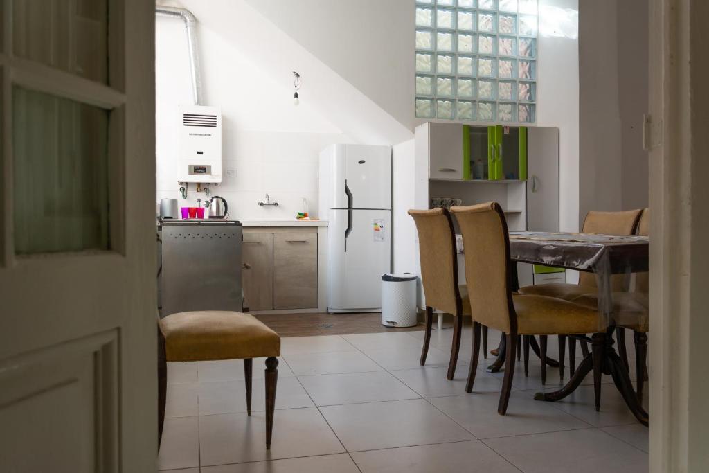 cocina con mesa, sillas y nevera en Amplio departamento en Villa Devoto en Buenos Aires