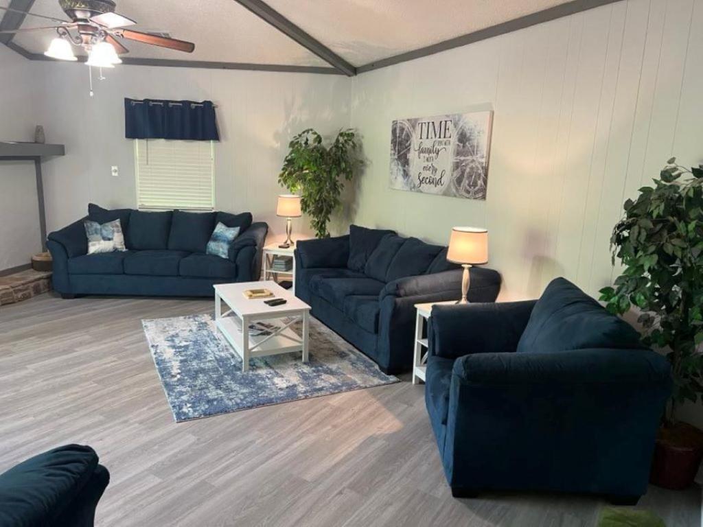 uma sala de estar com dois sofás azuis e uma mesa em Resort Home on .5 Wooded Acres Sleeps up to 12. Firepit for Smores! em Hot Springs
