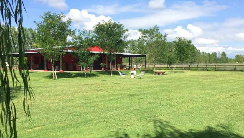 un gran campo de césped con un edificio en el fondo en Gran casa de campo en el Valle de Uco con espectaculares vistas DOLAR BLUE en Tunuyán