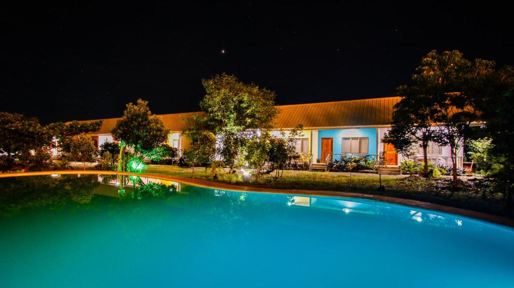 a large swimming pool in front of a house at night at Ana-as Apartelle (GGL) in Panglao Island