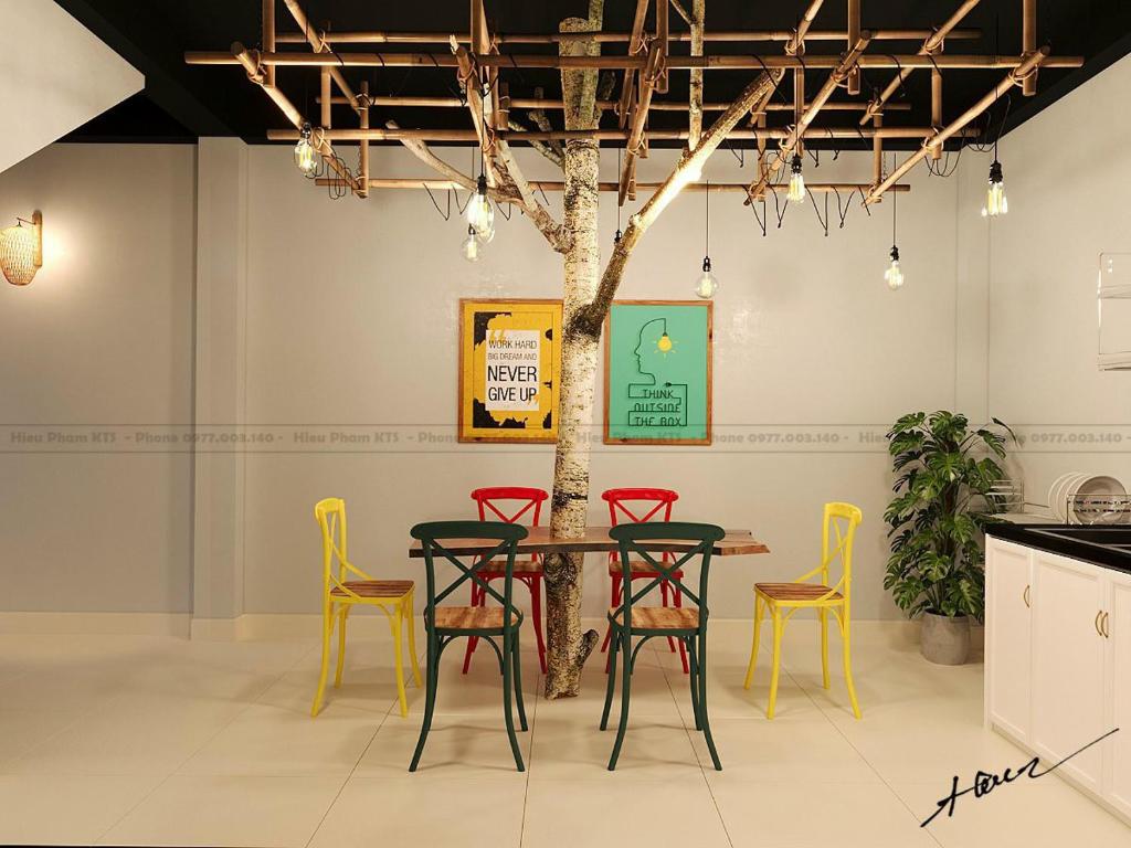 a table and chairs with a tree in a room at Homestay Casa 69 in Hanoi