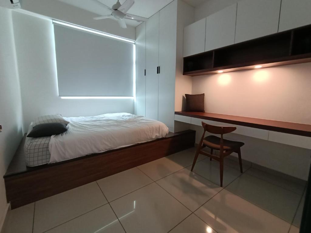 a bedroom with a bed and a desk and a chair at Studio Diane in Permatang Pauh