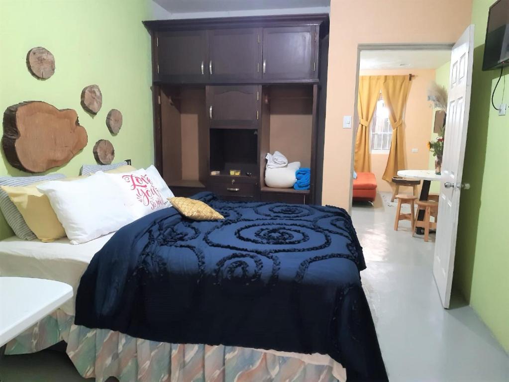 een slaapkamer met een bed met een zwart dekbed bij COMFY furnished private apartment.Netflix/internet in Chimaltenango