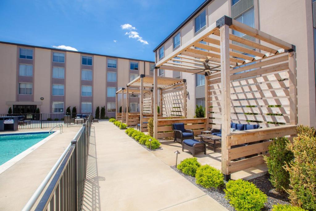 a patio with a pool and a wooden pergola at Holiday Inn St Louis SW - Route 66, an IHG Hotel in Saint Louis