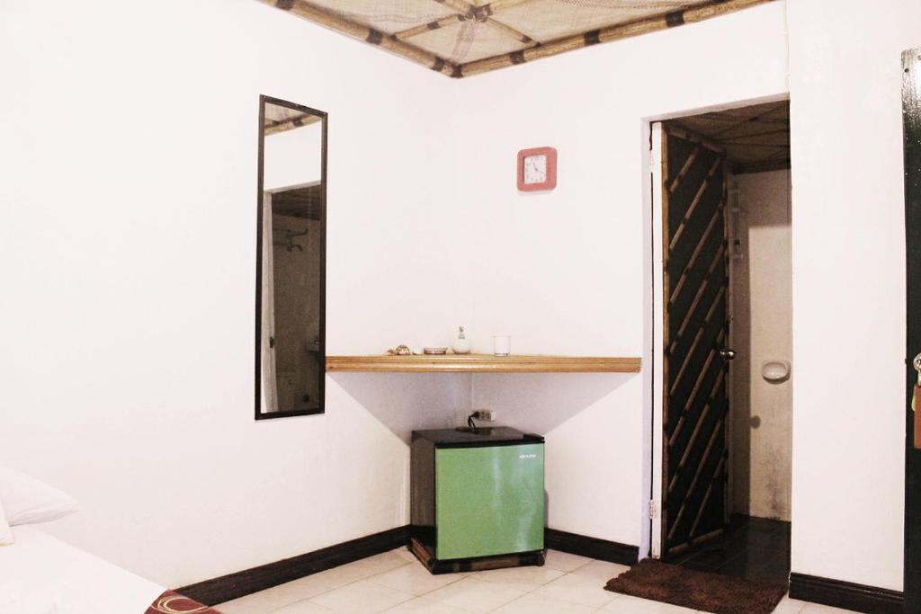 baño con armario verde y espejo en Turtle Cove Exclusive Island Resort en Calatrava