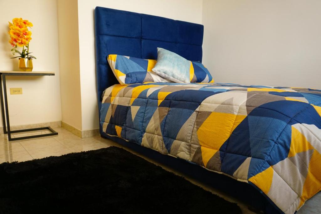 uma cama azul e amarela num quarto em Casa Familiar con Piscina en Urbanización privada em Manta