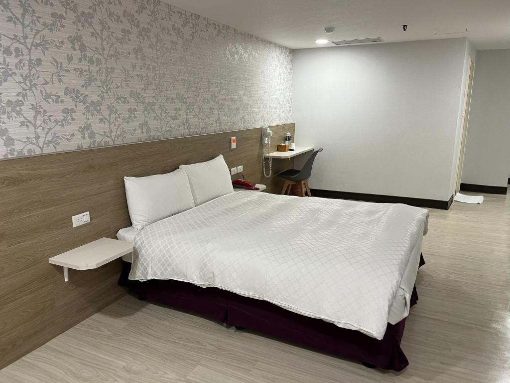 a bedroom with a large bed with a white comforter at Tie Dao Hotel in Tainan