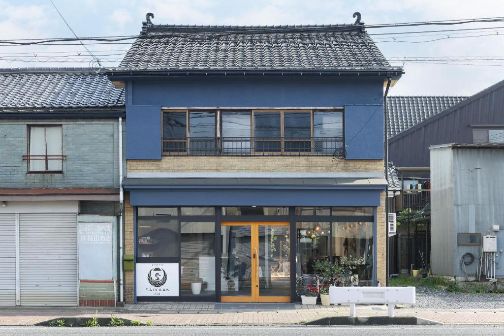 niebieski budynek przy ulicy miejskiej ze sklepem w obiekcie ゲストホテル宰嘉庵あおい/GuestHotelSAIKAAN_AOI w mieście Maizuru