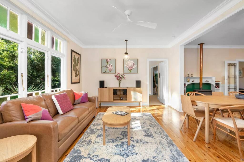 ein Wohnzimmer mit Sofa und Tisch in der Unterkunft Willow Tree Cottage in Bustling Creative Bundanoon in Bundanoon