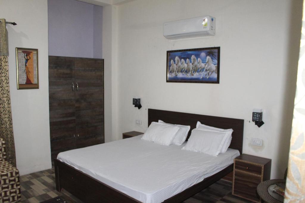 a bedroom with a bed with white sheets and pillows at AK Corbett Family Homestay in Rāmnagar