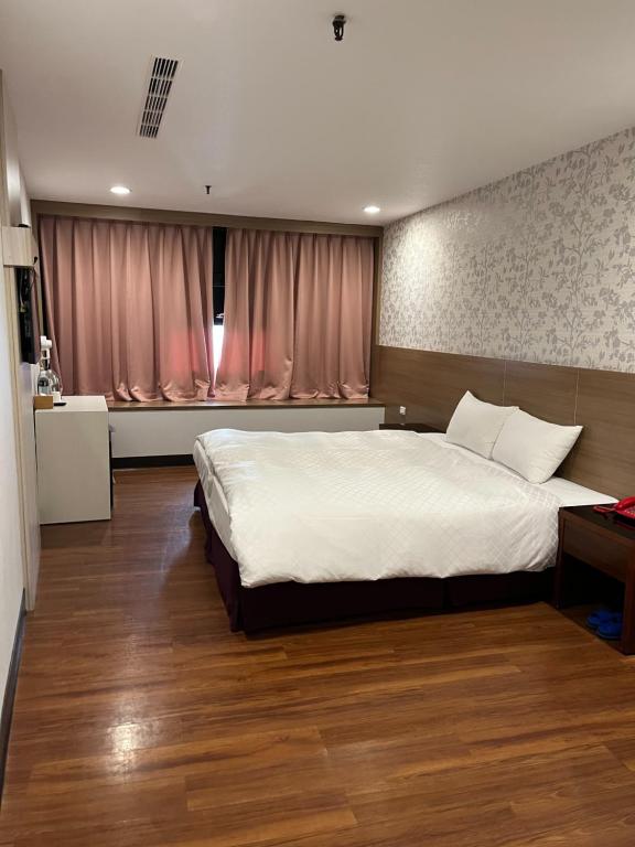 a bedroom with a large white bed in a room at Tie Dao Hotel in Tainan