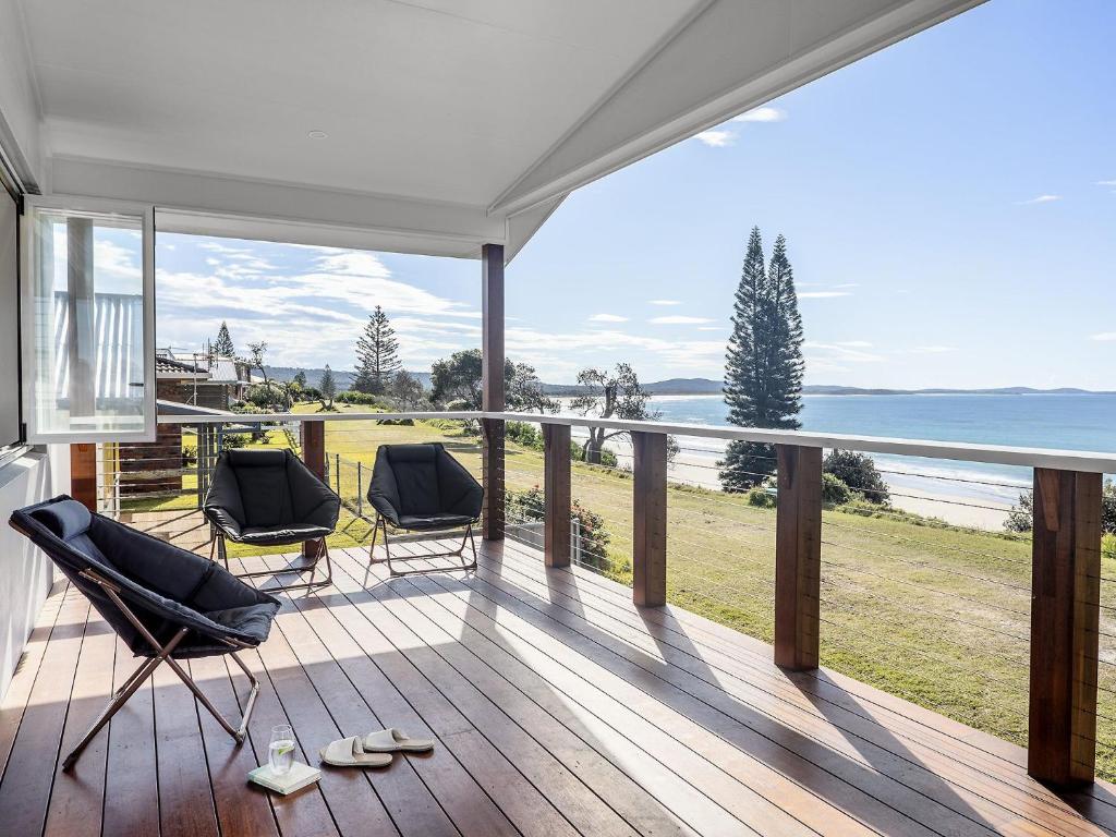 a balcony with two chairs and a view of the ocean at Aqua Vista - Beach front location in Brooms Head