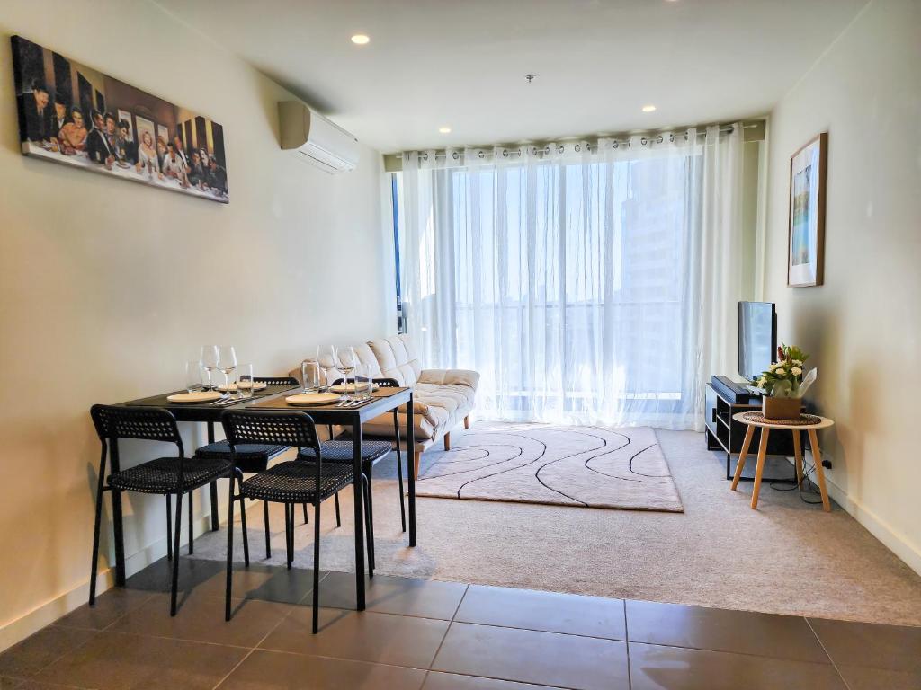 a living room with a table and chairs and a couch at Modern 2-bedrooms apartment with parking in Melbourne