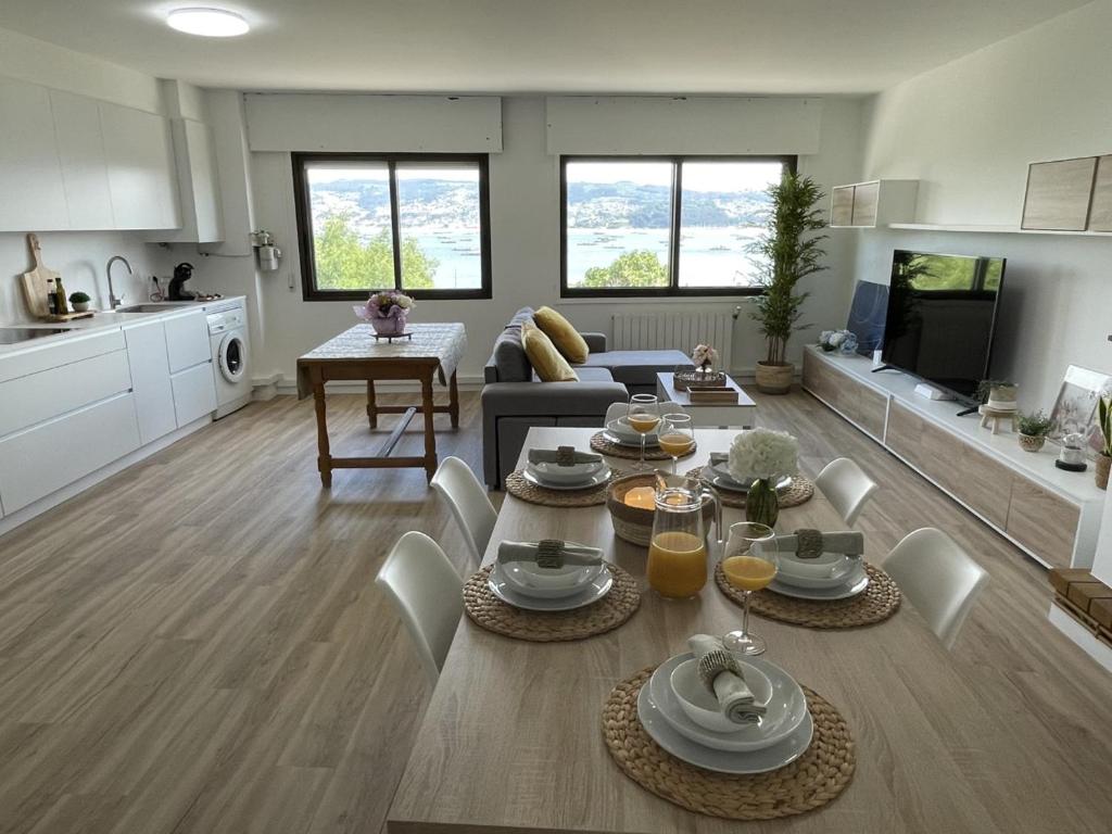 een keuken en een woonkamer met een tafel en stoelen bij Mirador Puerto Náutico in Moaña