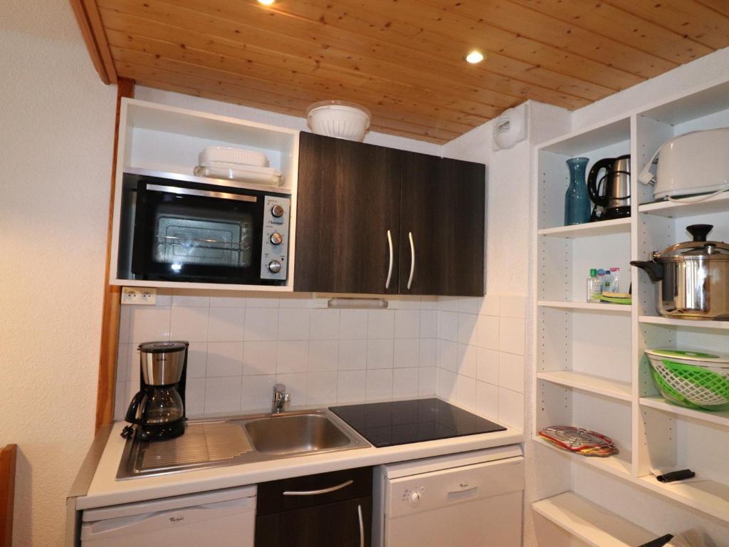 une petite cuisine avec un évier et un micro-ondes dans l'établissement Appartement skis aux pieds avec balcon, cabine, animal accepté, Tignes Val Claret - FR-1-502-511, à Tignes