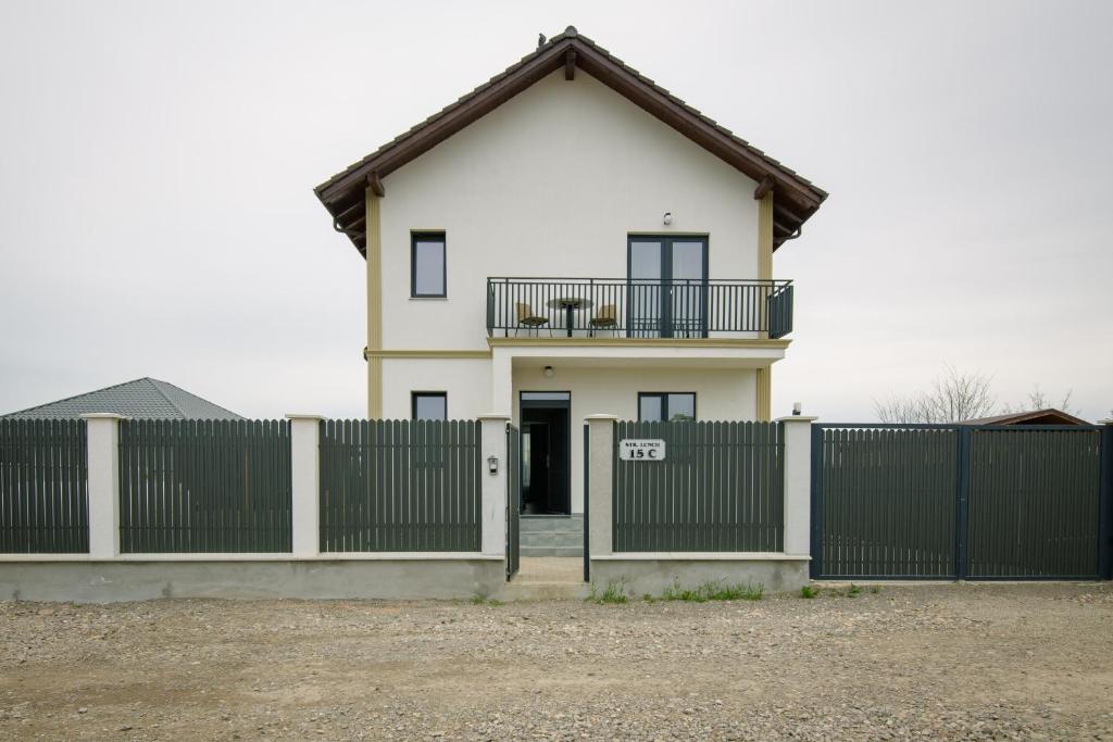 una casa blanca con una puerta y una valla en Casa Lucan Brașov en Brasov