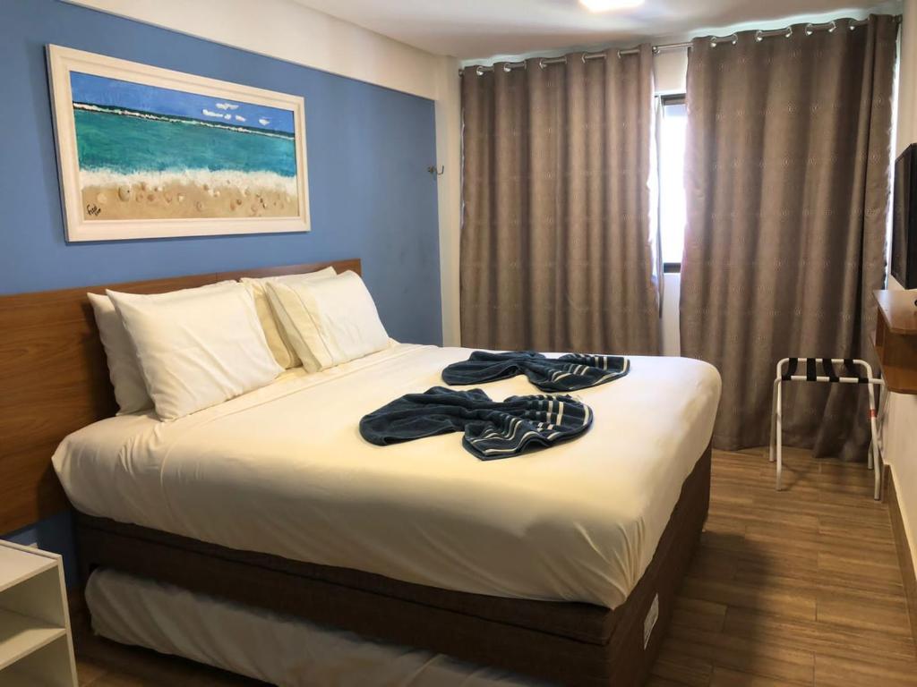 1 dormitorio con 1 cama con toallas en La Fleur Polinesia Residence & Resort, en Porto de Galinhas