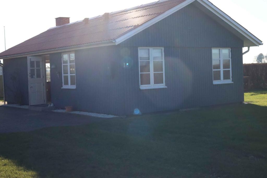 een klein huis met een gazon ervoor bij Hasselvnget 16, 5450 Otterup in Otterup