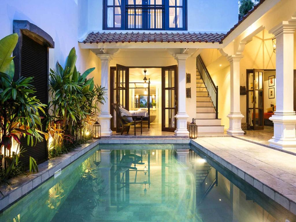 a house with a swimming pool in front of a house at Villas Sabbia in Seminyak