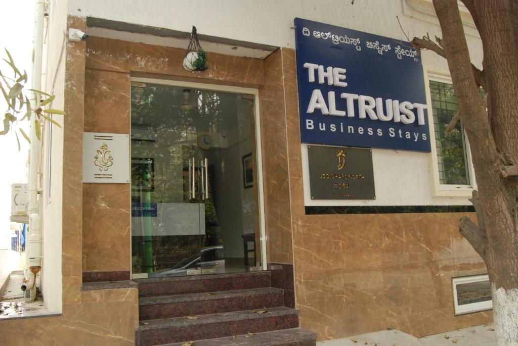 een gebouw met een bord dat de zakelijke verblijven van de kunstenaar leest bij The Altruist Business Stays, Manayata Tech Park in Bangalore