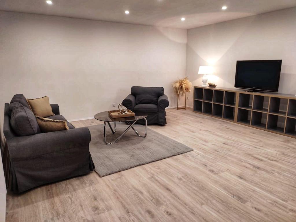 ein Wohnzimmer mit 2 Stühlen und einem TV in der Unterkunft Frankenholzer Ferienwohnung in Bexbach
