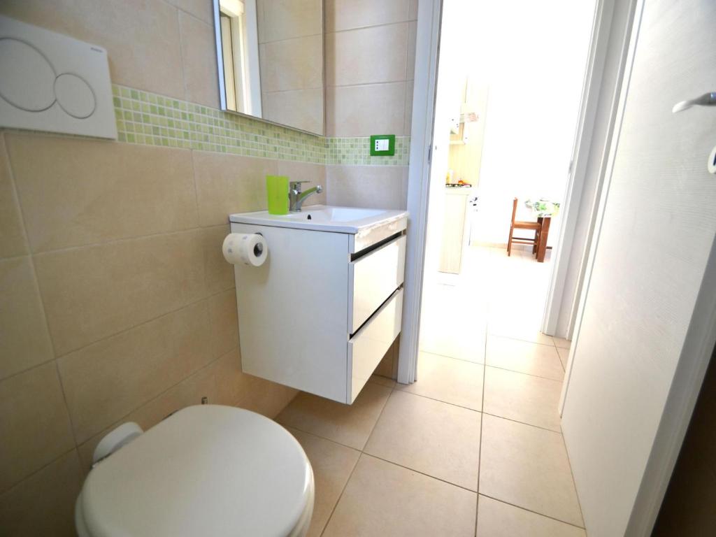 Łazienka z białą toaletą i umywalką w obiekcie Charming Apartment In Central Location With Air Conditioning Pets w mieście Torre dell'Orso